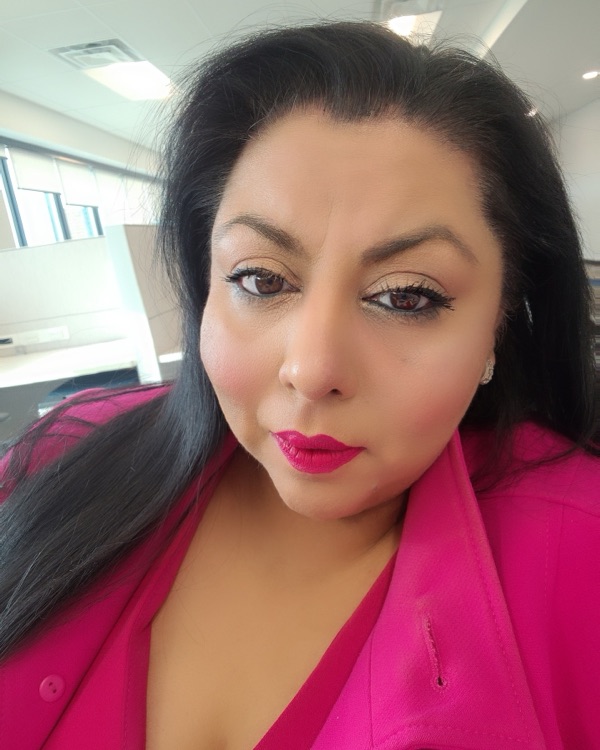 Izza Masud, founder of Distilligent, in a bright pink blazer.